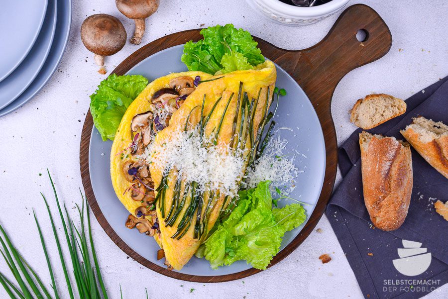 Omelett Soufflé mit Käse, Pilzen und Gemüse als hübscher Eierkuchen